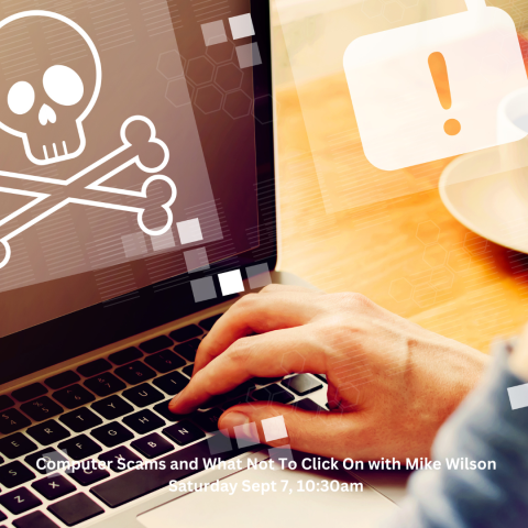 hand on laptop keyboard with skull and crossbones on screen